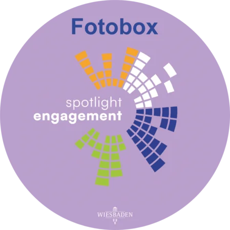 Ein violettes Logo-Design für eine Fotobox-Magnetfolie. Das Design beinhaltet die Wörter "Fotobox," "spotlight" und "engagement" sowie das Wappen der Stadt Wiesbaden.