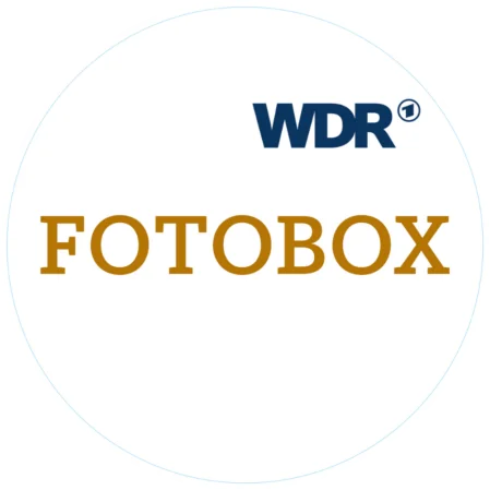 Ein rundes, weißes Logo-Design für eine Fotobox-Magnetfolie. Das Design enthält den blauen WDR-Schriftzug und den braunen Schriftzug "FOTOBOX".