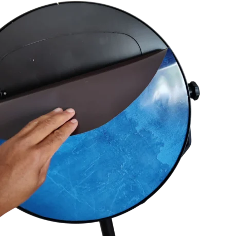 Eine Hand legt eine dunkelbraune Magnetfolie über das blaue Design einer Fotobox. Dies demonstriert, wie einfach das Branding für die Kunden ist.